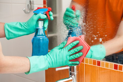 Cleaner in Chiswick using protective gloves while preparing cleaning products