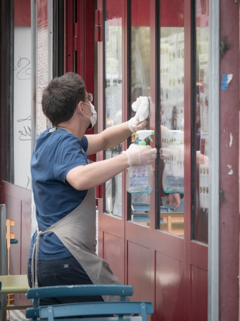 The image shows a commercial shopfront on Chiswick High Road with large frosted glass windows and a black metal frame, set within a brick building. The windows are clean and free of smudges or dirt, s